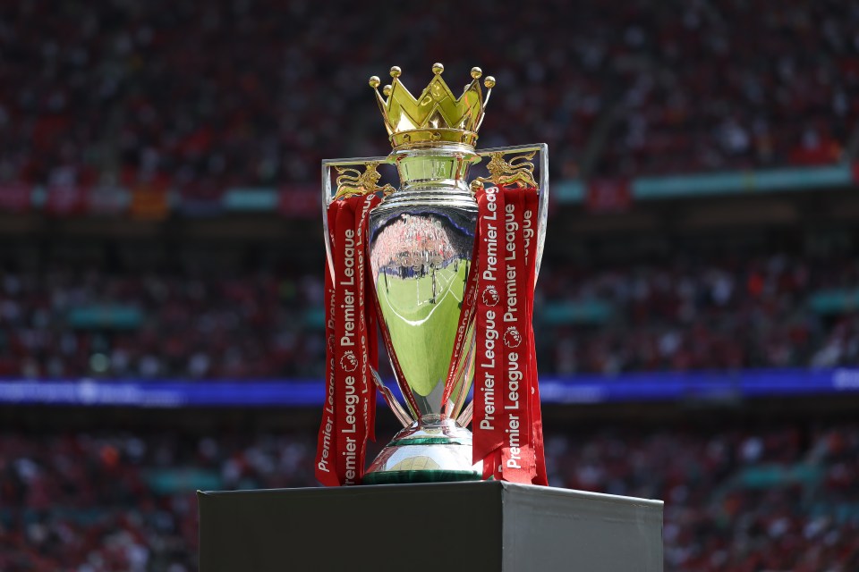 Premier League trophy on display at a stadium.