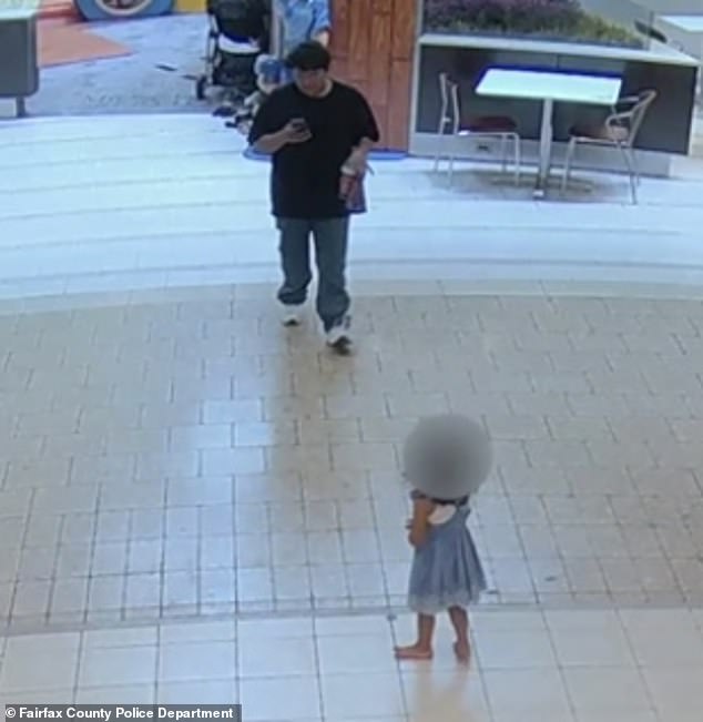 The man is seen here approaching the three-year-old girl after she wandered from an indoor play area