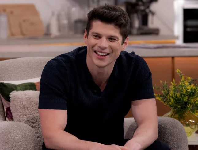 Man smiling while sitting on a couch.