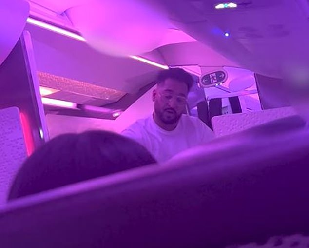 The person filming the interaction can be heard saying 'holy s***' as Iftikhar goes back to his seat following the tirade where he threatened to gang rape a stewardess