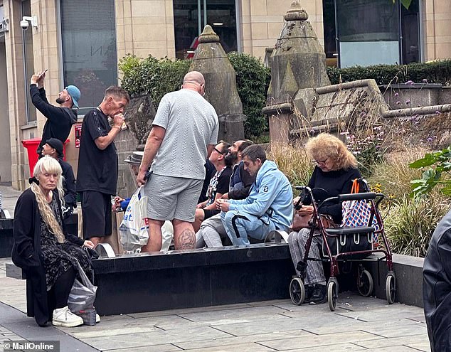 A group of females and males were seen at a seated concrete area outside NatWest bank drinking and seemingly doing drugs when the Daily Mail visited