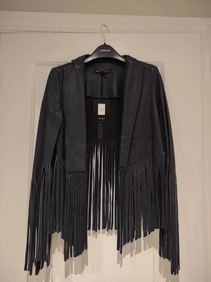Black leather cropped jacket with fringe.