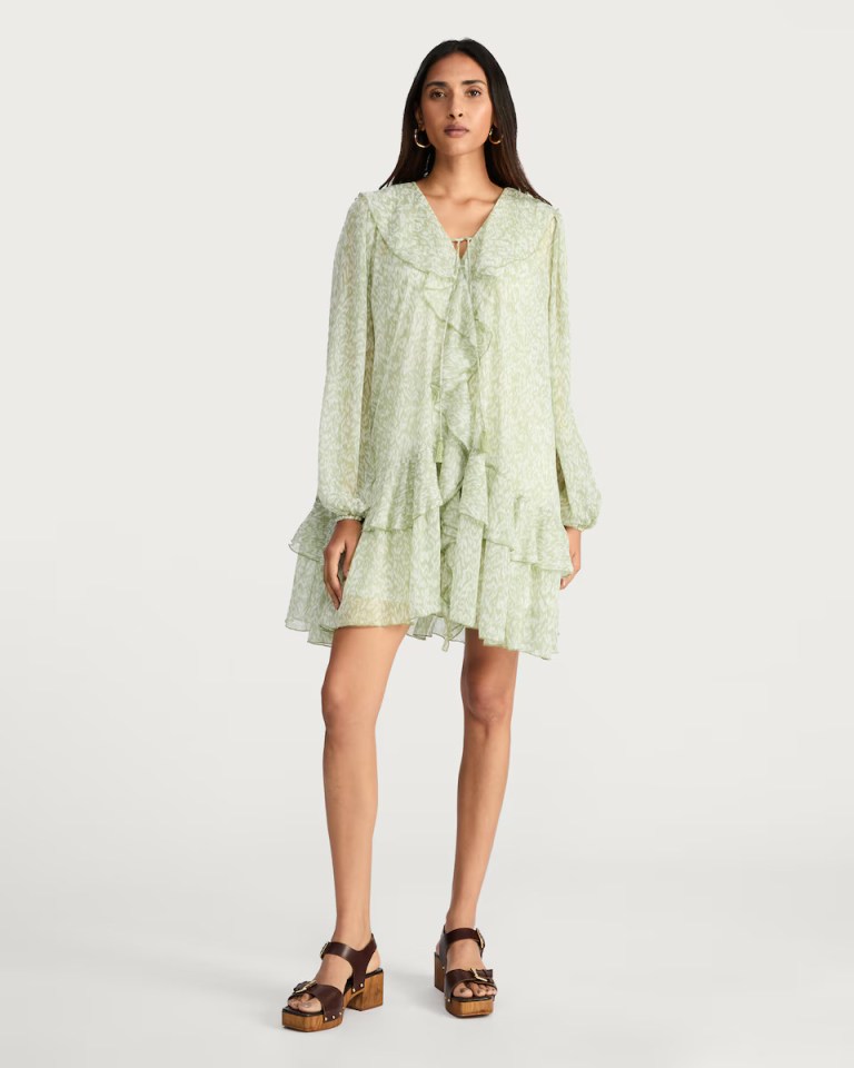 Model wearing a light green ruffle dress.