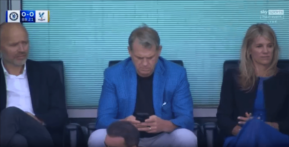 Screenshot of three people sitting and watching a soccer game.