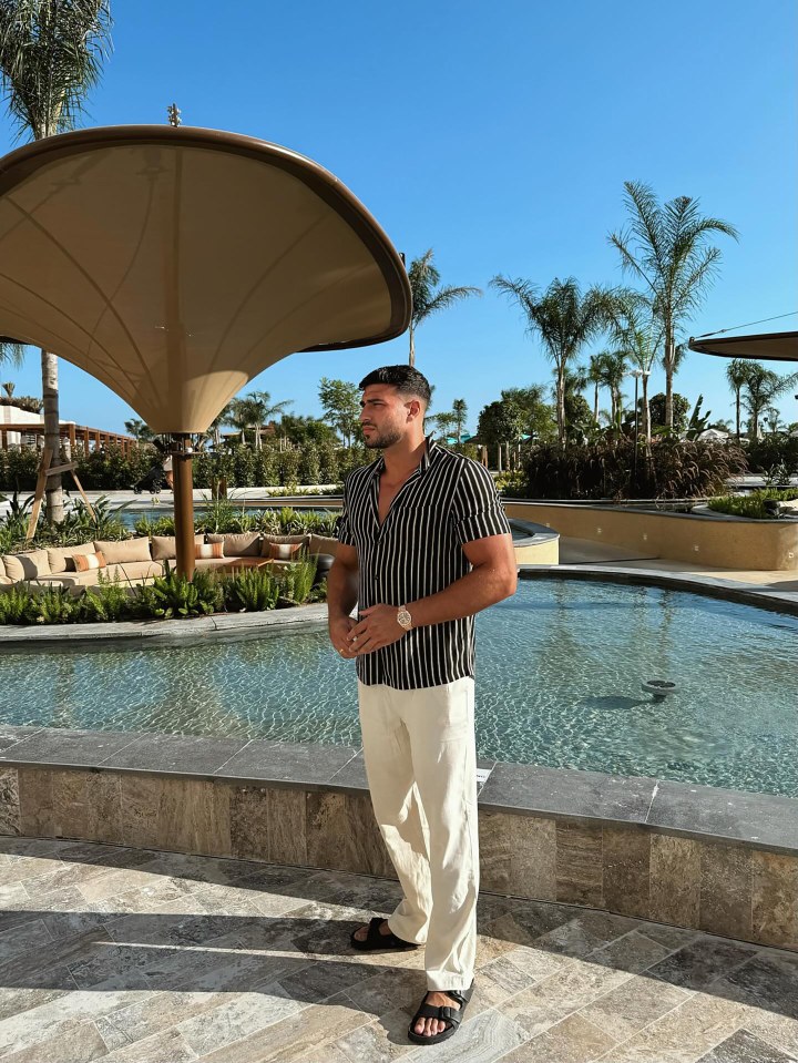 Tommy Fury standing by a pool.