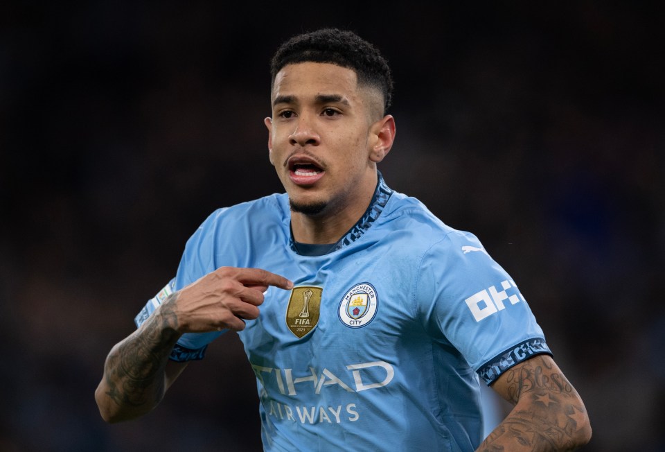Savinho of Manchester City celebrating a goal, pointing to the FIFA World Champions 2023 badge on his jersey.