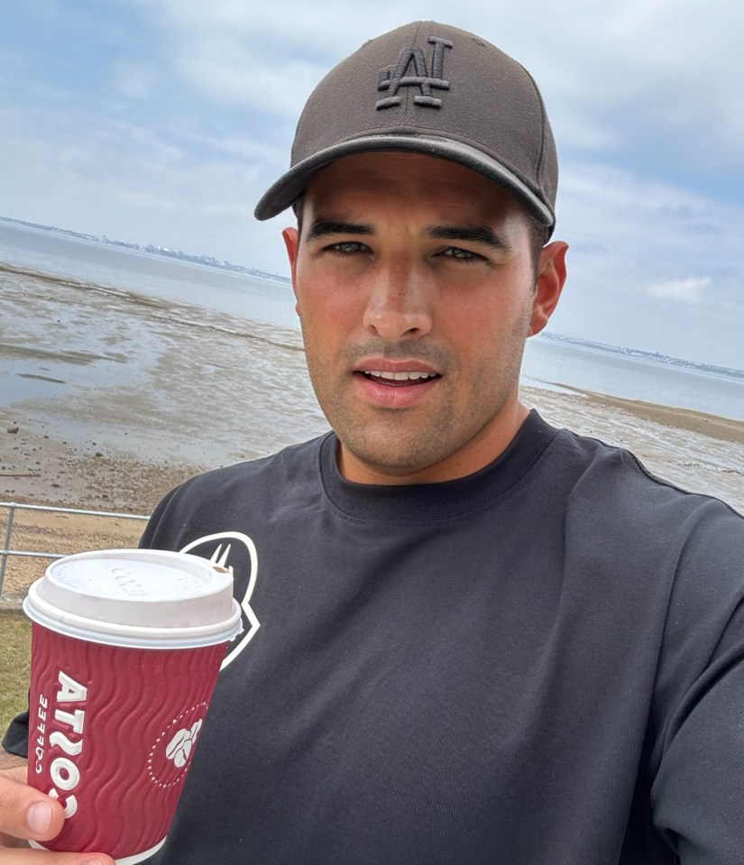 Man holding a Costa Coffee cup outdoors.