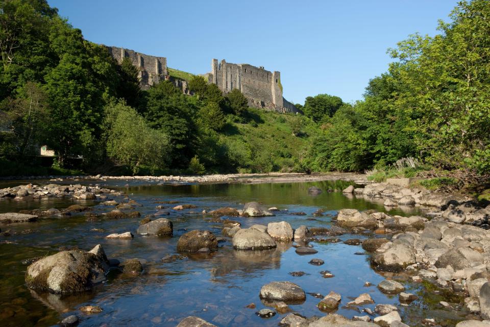 Ruins of Richmond Castle overlooking a river.