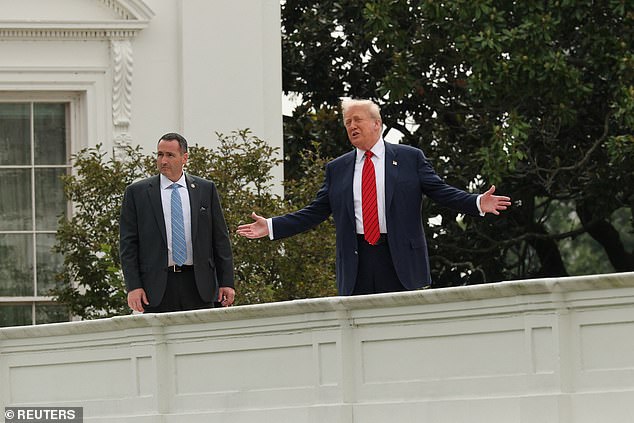 President Donald Trump engages with reporters from the White House roof during a 'tour' on Tuesday as he hinted that there could be more renovations, financed by him, announced
