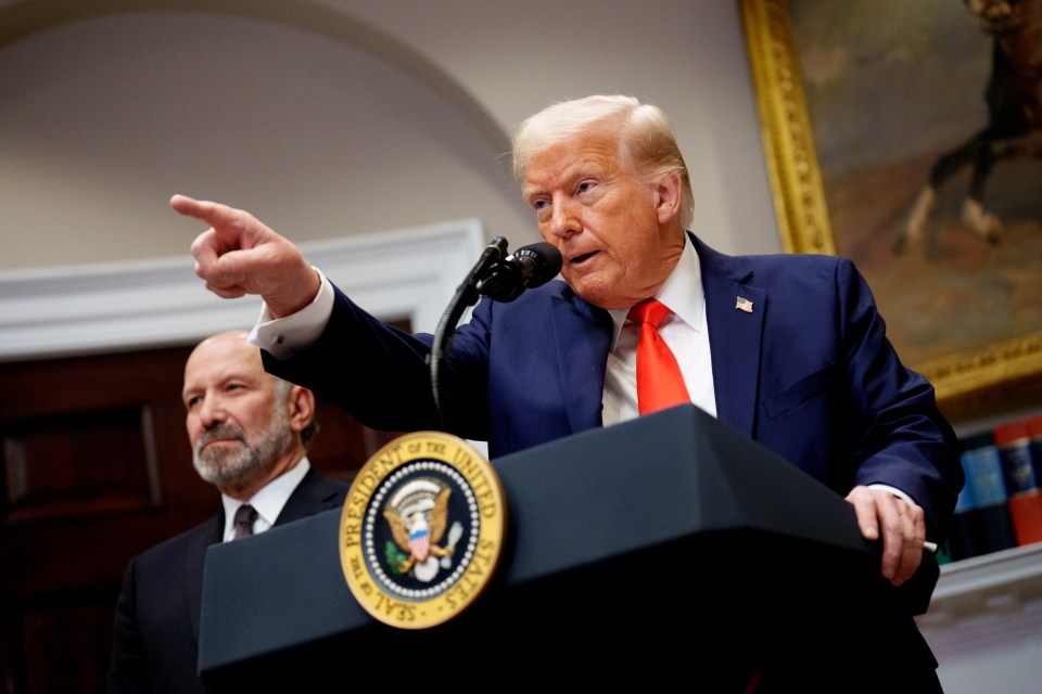 President Donald Trump speaking at a podium, pointing.