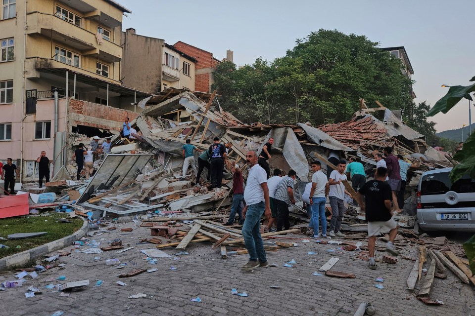 People removing debris from a collapsed building after an earthquake.
