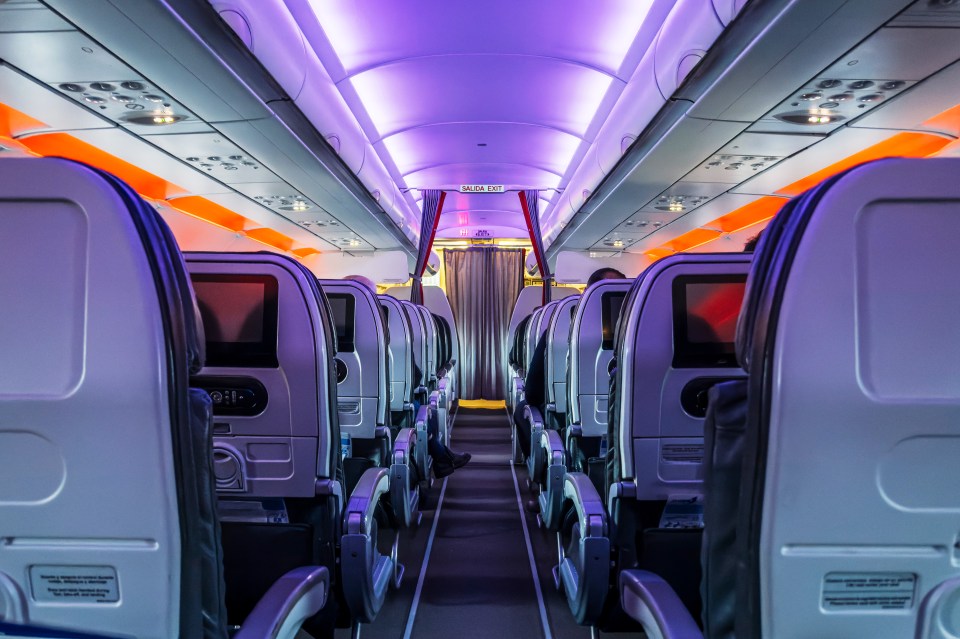 Airplane passenger cabin aisle at night.