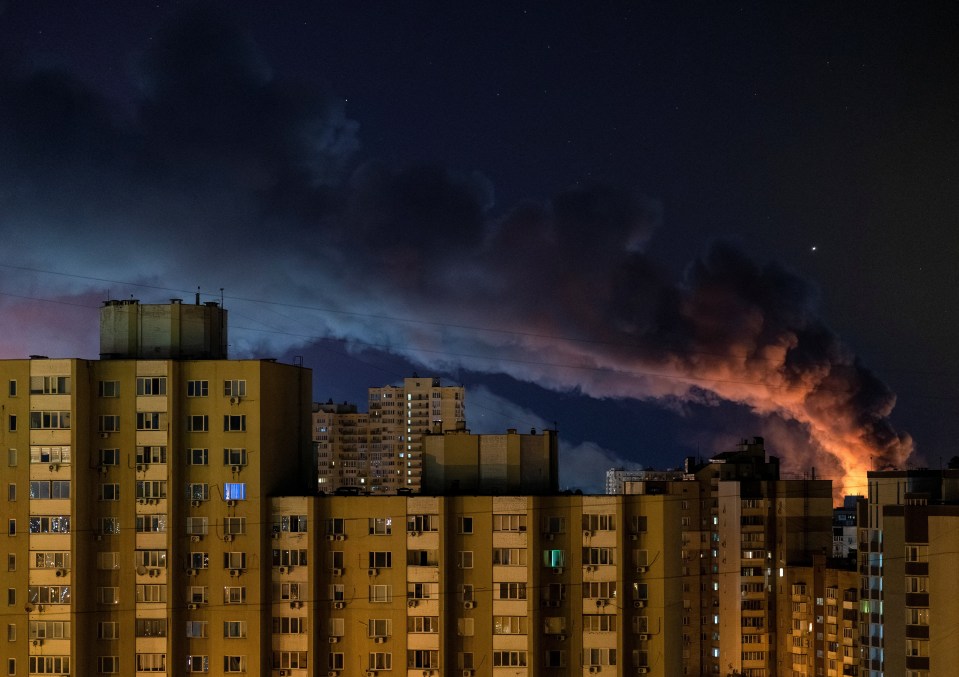 Smoke rises over Kyiv apartment buildings at night following Russian missile strikes.