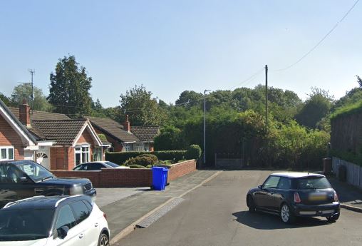 Residential street with houses and cars.