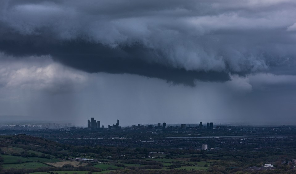 Manchester skyline under a stormy sky.