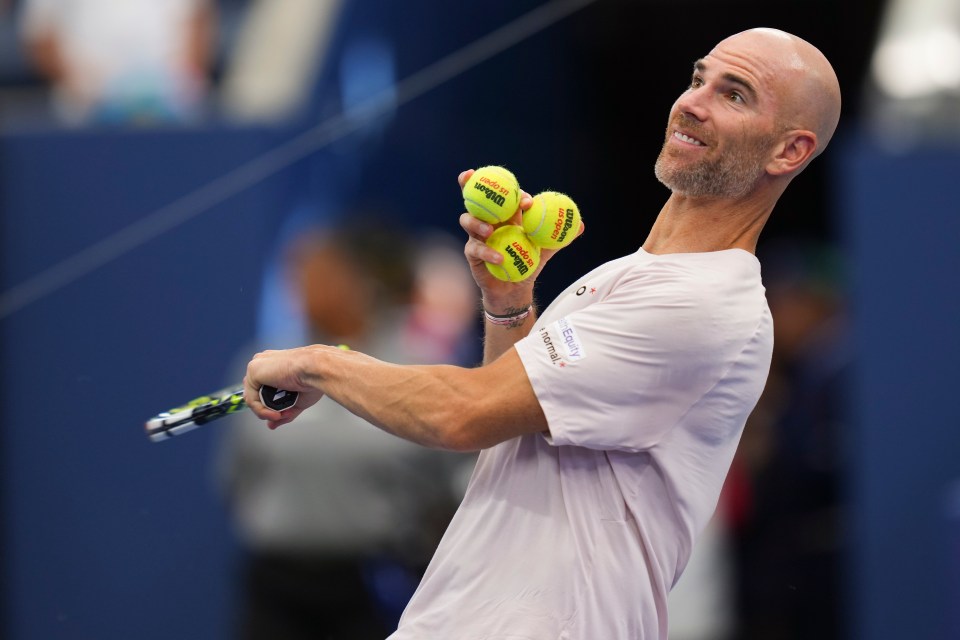Adrian Mannarino tossing tennis balls to the crowd.
