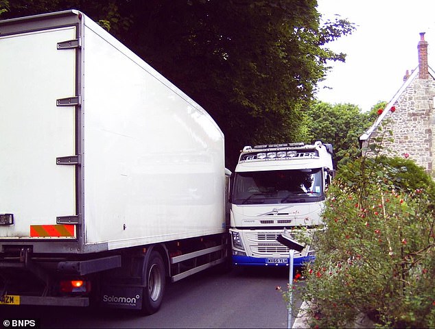 Two lorries struggle to pass each other on a narrow part of the C13 road in Melbury Abbas