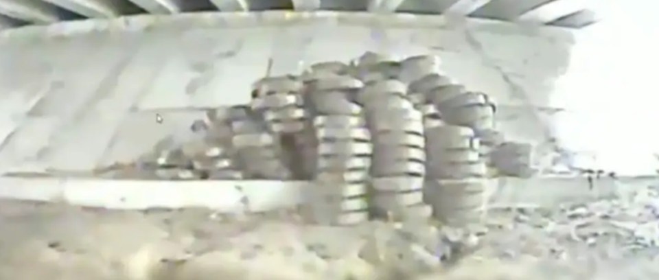 Screenshot of tire stacks under a bridge.