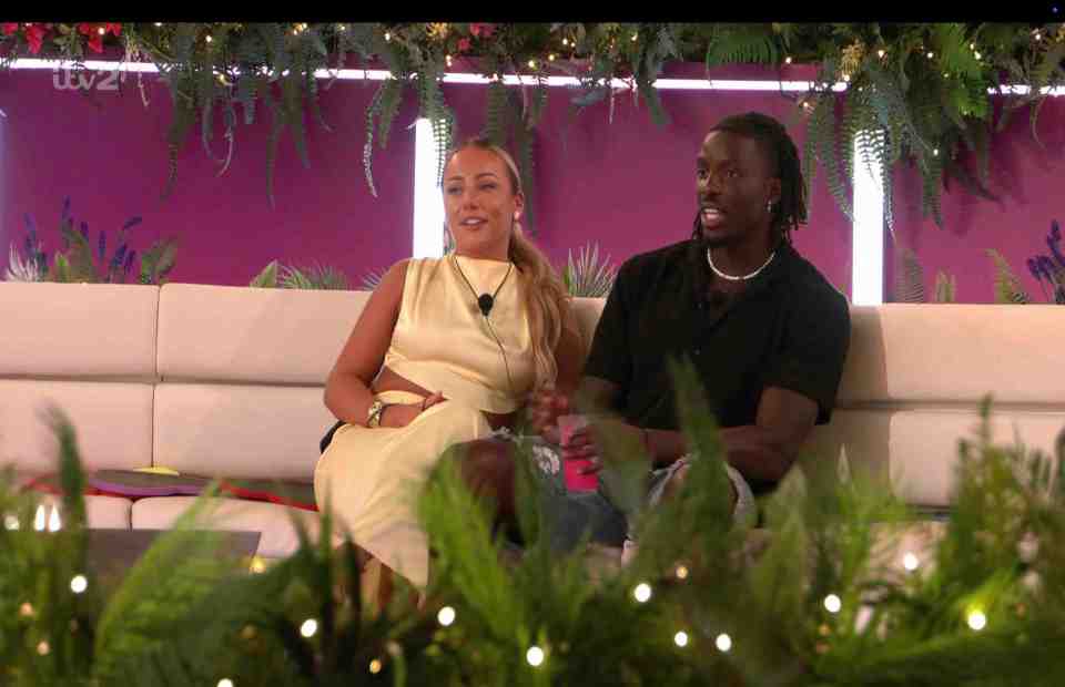 Meg and Dejon from Love Island sitting on a couch.