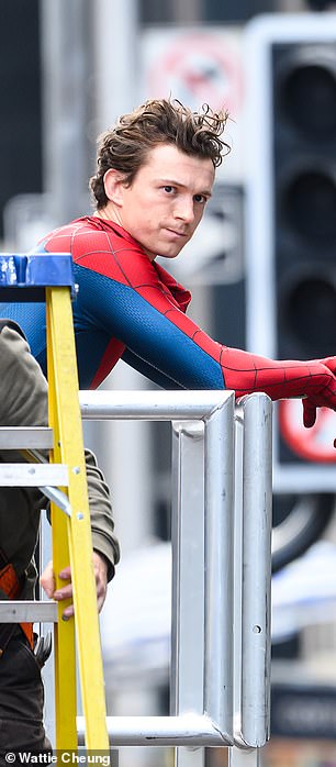 Tom reset on the railings of the set during filming after Glasgow was transformed into New York over the past few days