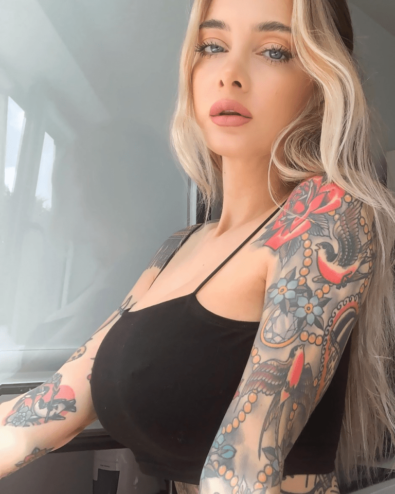 Woman with blonde hair and tattoos on her arms.