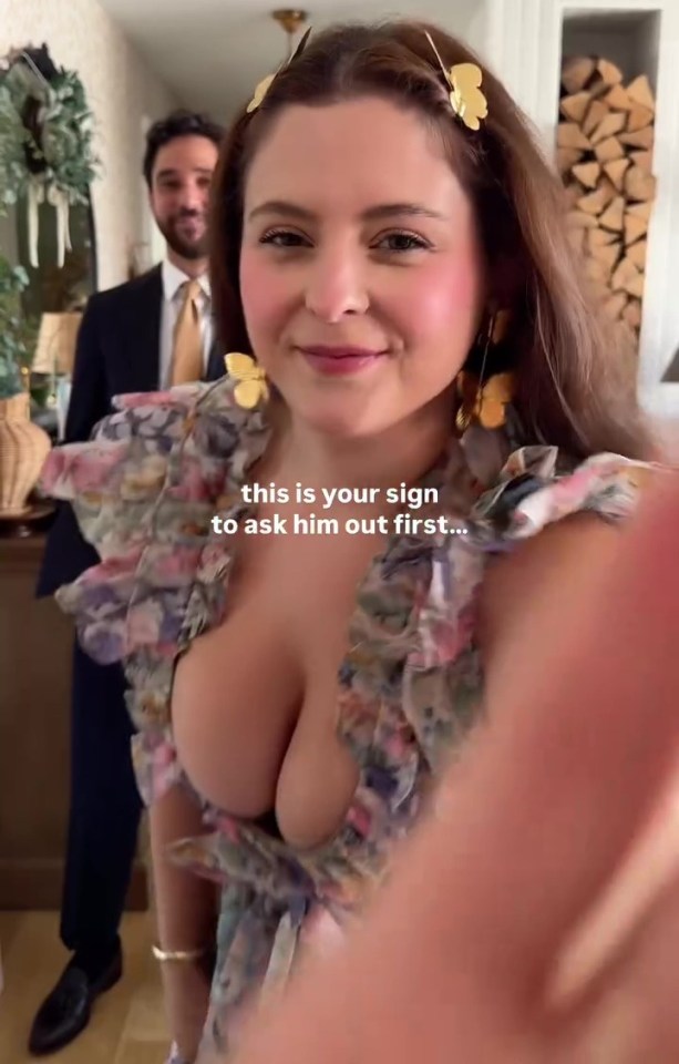 Woman in low-cut dress with a man in the background; text overlay reads "this is your sign to ask him out first..."