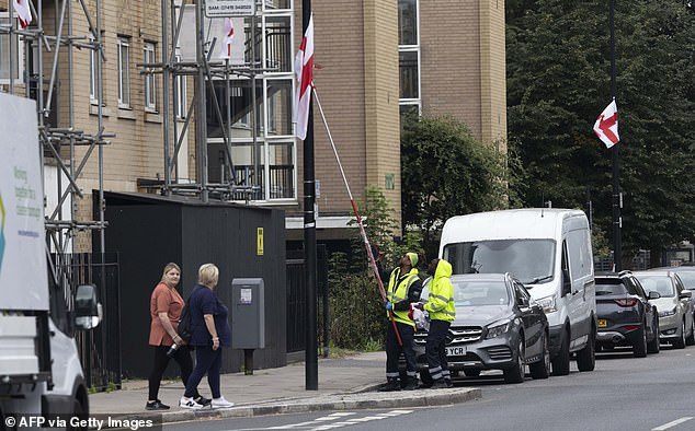 Council workers in Tower Hamlets, east London, were met with abuse as they began to tear down England and Union Jack flags which were hung by patriotic campaigners (pictured)