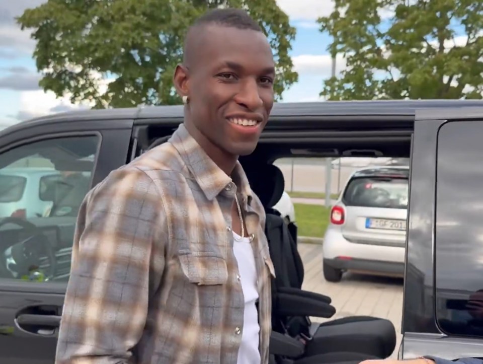 Man smiling while getting out of a car.