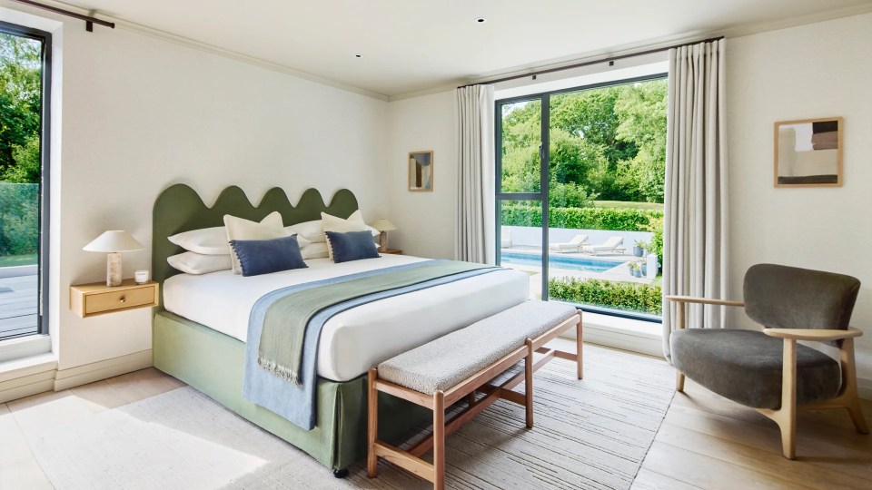 Bedroom with green bed and pool view.