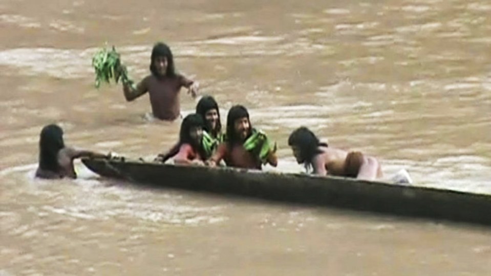 Members of the Mashco Piro tribe in a canoe on a river.