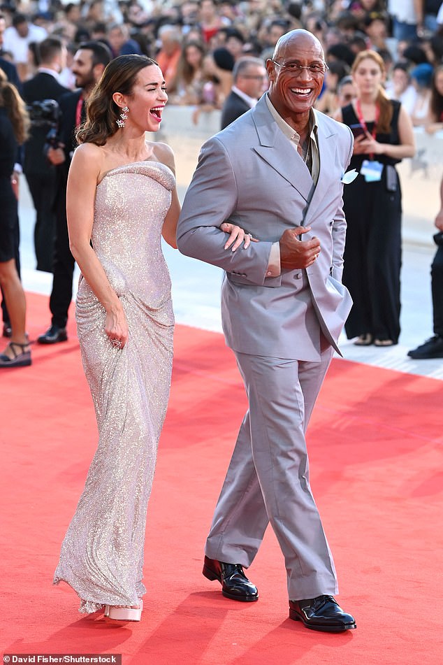 She was joined by dapper co-star The Rock, whose real name is Dwayne Johnson, as he beamed for photos wearing a smart grey suit and white open collar shirt
