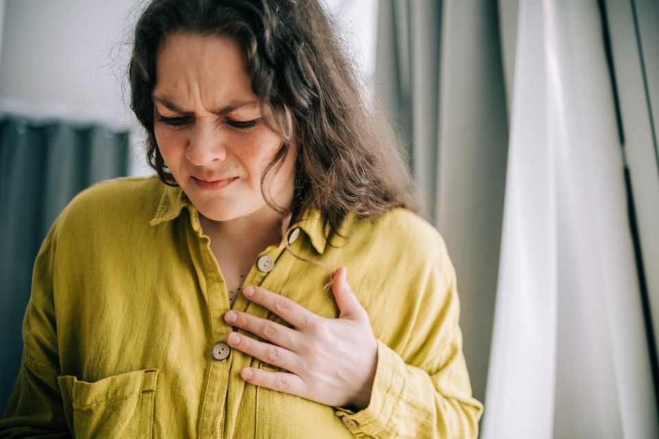 Woman holding her chest in pain.