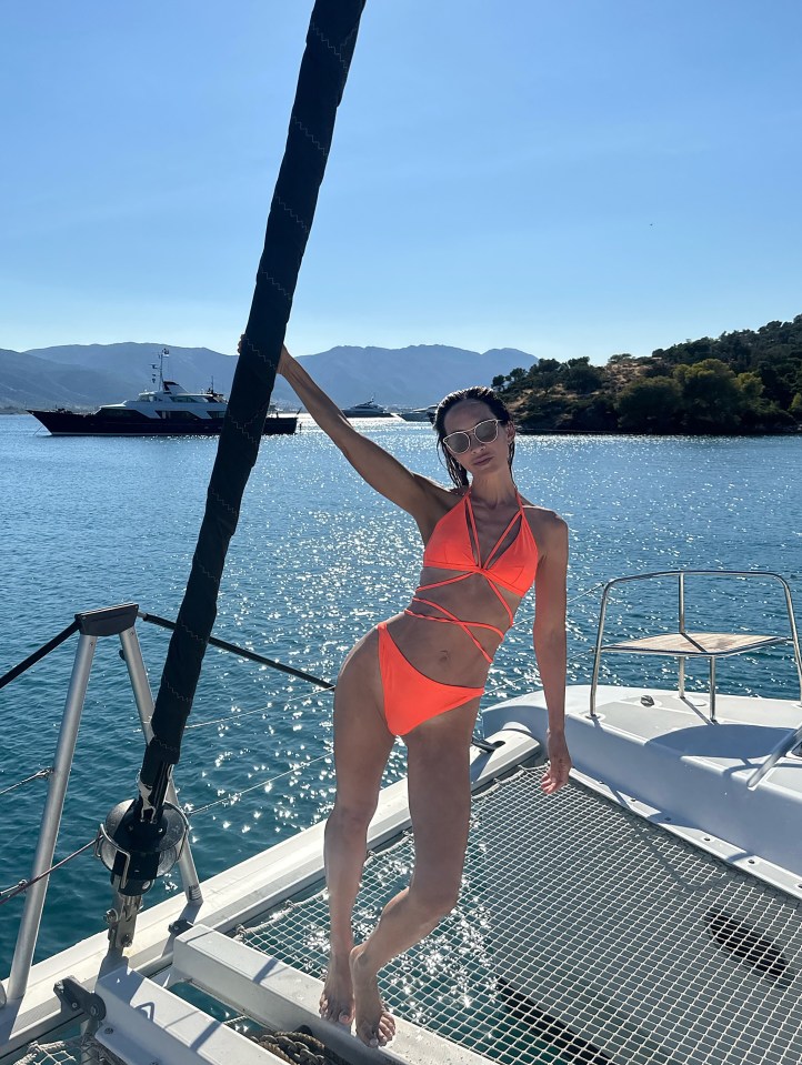 Woman in orange bikini on a boat in Greece.