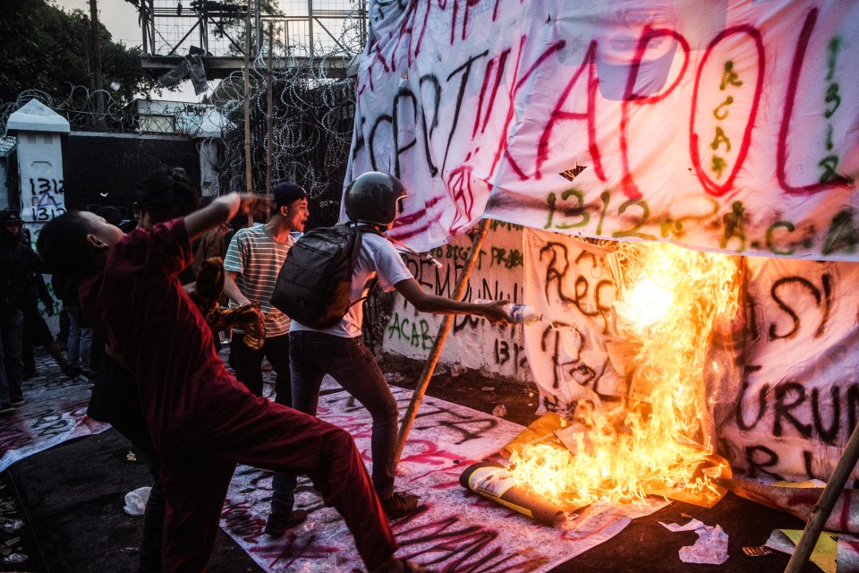Protesters burning banners at a demonstration demanding police reform and parliament dissolution in Bandung, Indonesia.