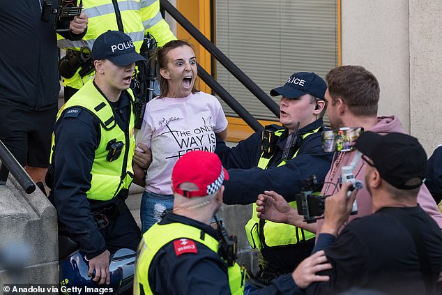 Campaigner Sarah White is arrested outside The Civic Offices during a protest against housing of asylum seekers at The Bell Hotel in Epping