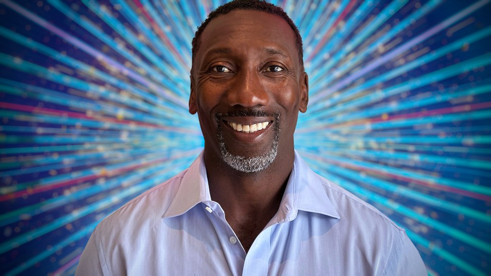 Portrait of a smiling man against a sparkly background.