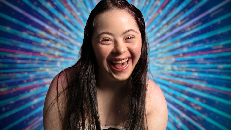 Happy young woman with long dark hair laughing.
