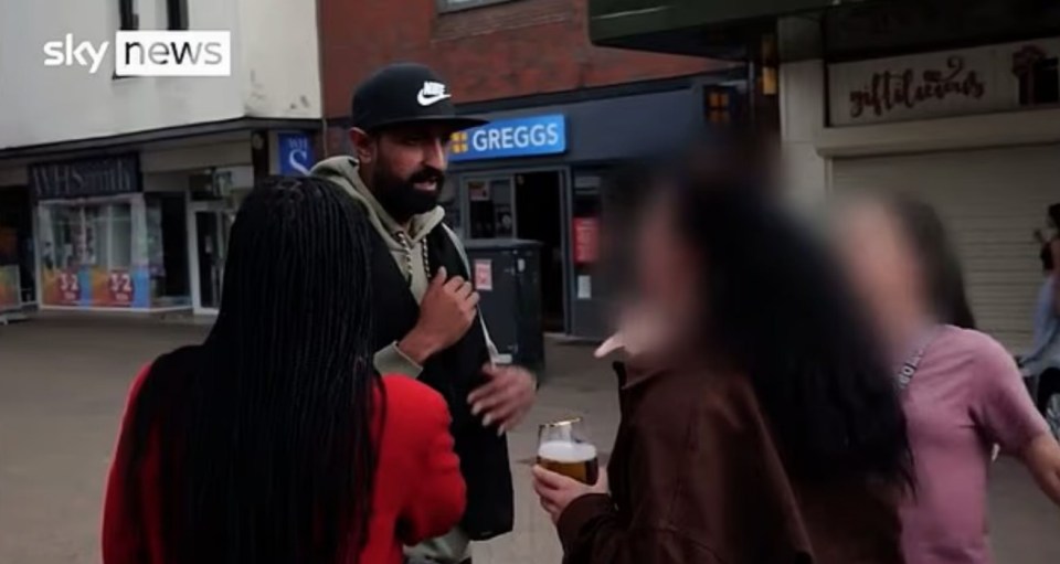 TV CHAOS Vile moment woman storms TV interview with beer in hand to hurl racist abuse at local businessman - with KIDS in tow, , This is the moment a local business owner is racially abused in broad daylight by foul-mouthed passerby in Nuneaton town centre. , , In a video circulating on social media, local business owner Zahin, 32, was being interviewed by Sky News about the divide in the town over attitides to asylum seekers., , He has only just started to speak, stating his age, when he is interrupted by two women walking along the street with what appears to be a group of children.