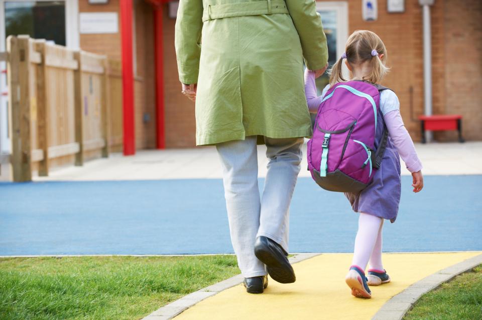 Grandparent and grandchild walking to school.
