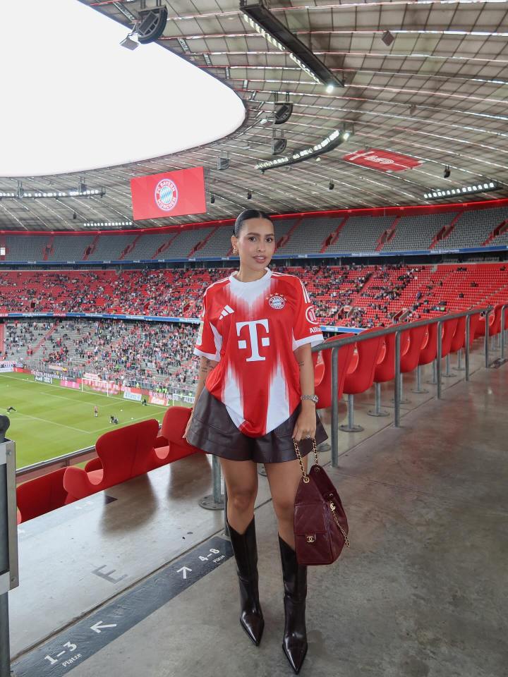 Woman in Bayern Munich jersey at a stadium.