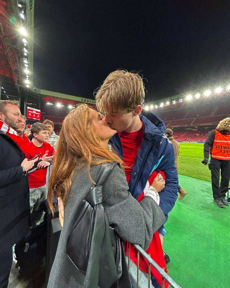 Couple kissing at a soccer game.