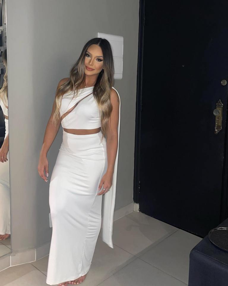 Woman in white one-shoulder dress and long skirt.