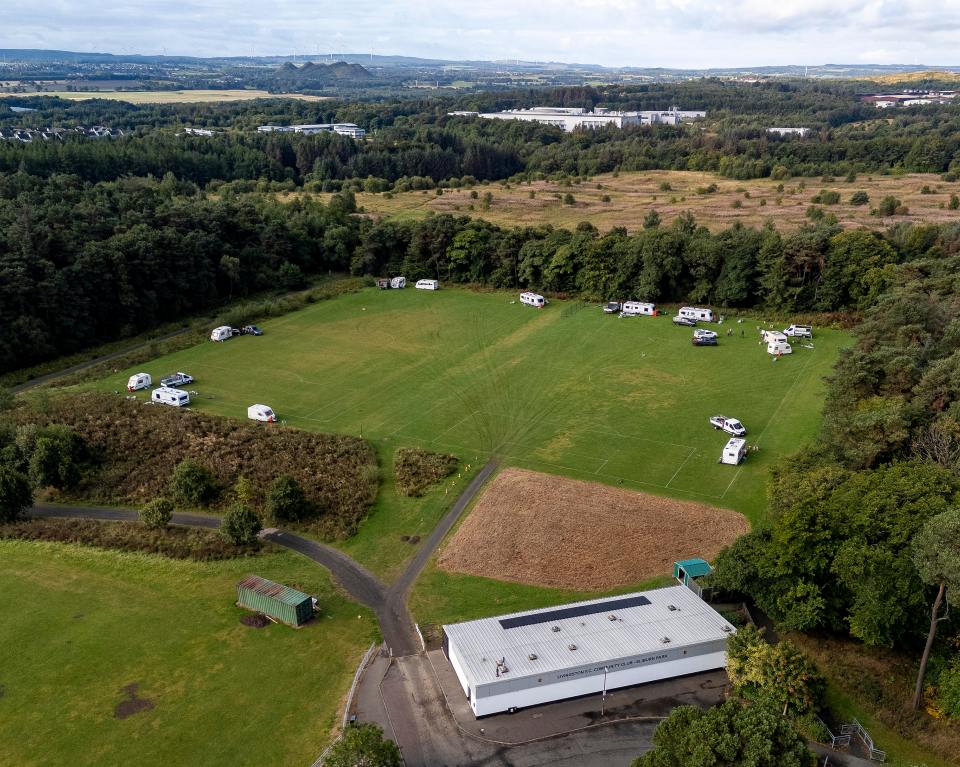 Aerial view of caravans parked on a football pitch.