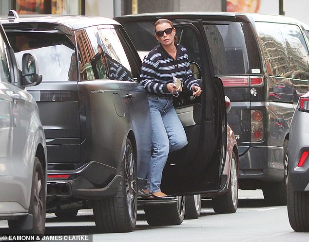 She accessorised with dark sunglasses, while using a white crossbody bag to carry her belongings