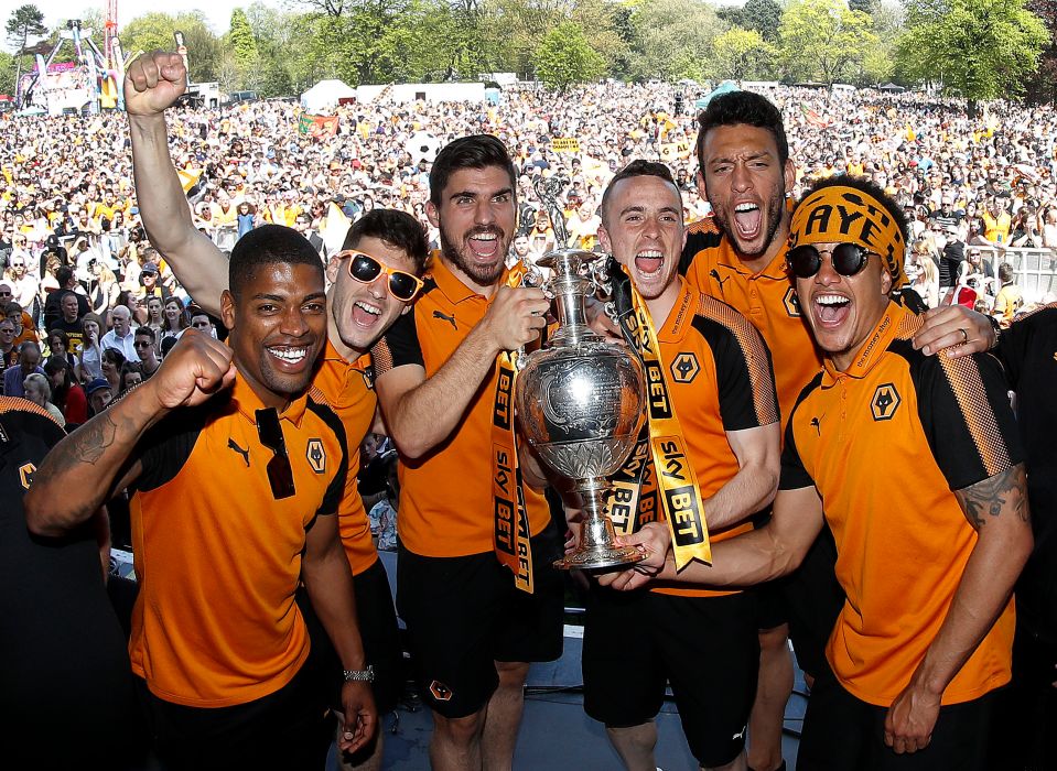 Wolverhampton Wanderers players holding the Sky Bet Championship trophy at a winner's parade.