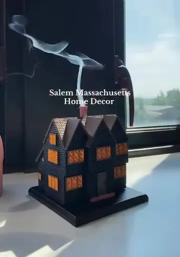 House-shaped incense burner with smoke rising from chimney.