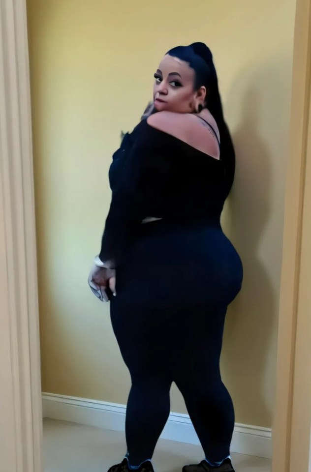 Woman in black leggings and top, looking over her shoulder.