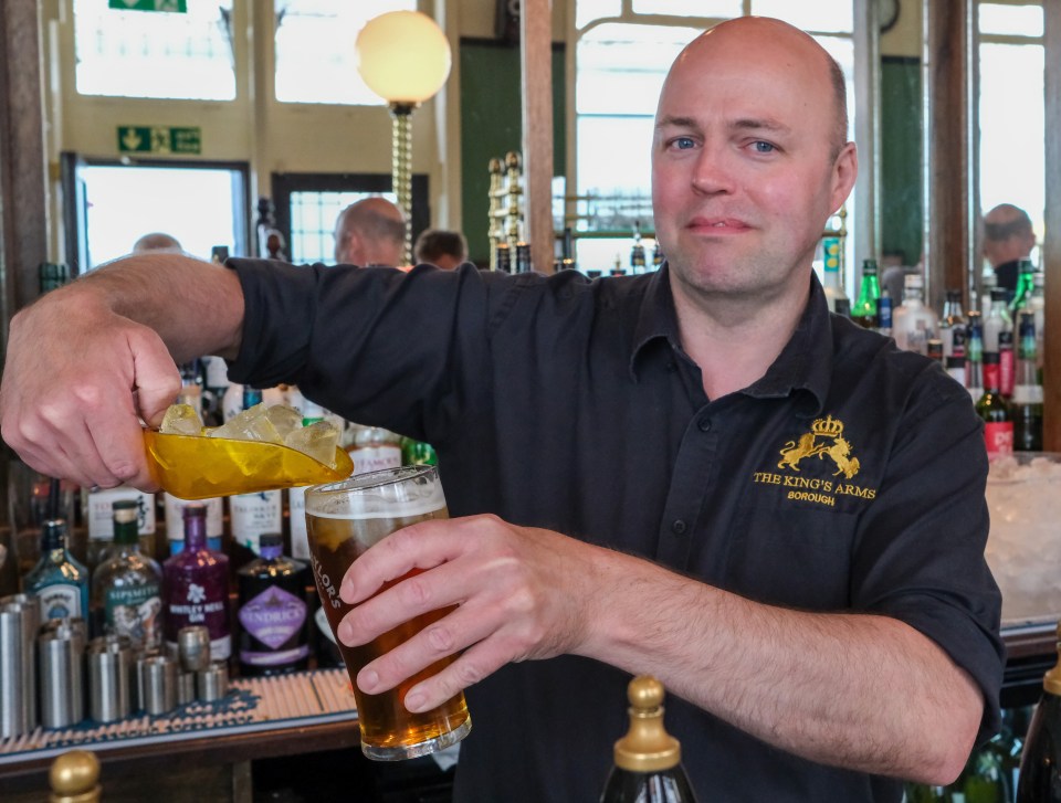 Bartender adding ice to a beer.