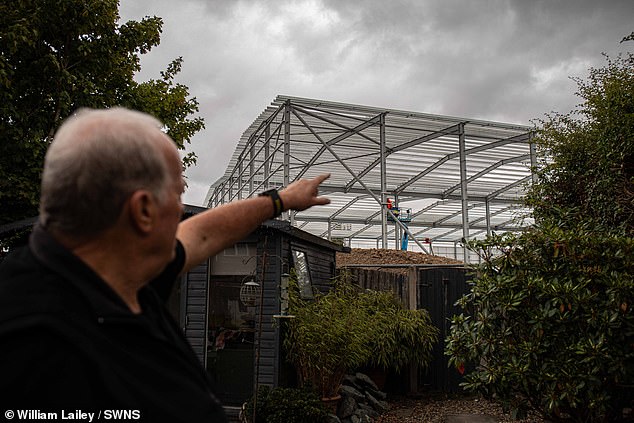 People in Tyldesley, Wigan, including Steve Retford, pictured, have been left horrified after 60-foot tall warehouses were built just metres from their homes