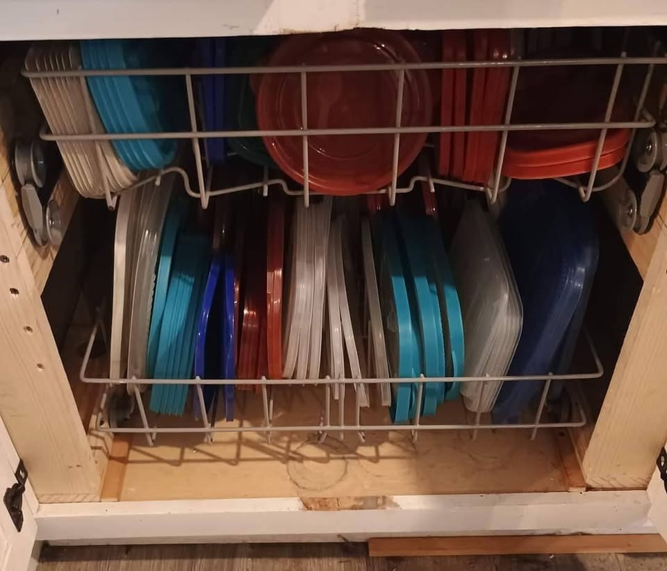 Plates and lids stored in a kitchen cabinet.